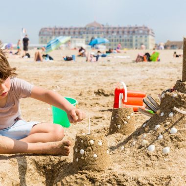 A child building sandcastles on Deauville beach
