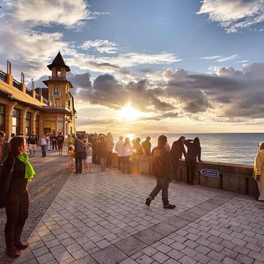 Promeneurs au coucher de soleil devant le casino de Granville